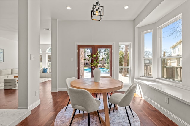 dining area with a healthy amount of sunlight, dark wood finished floors, visible vents, and baseboards