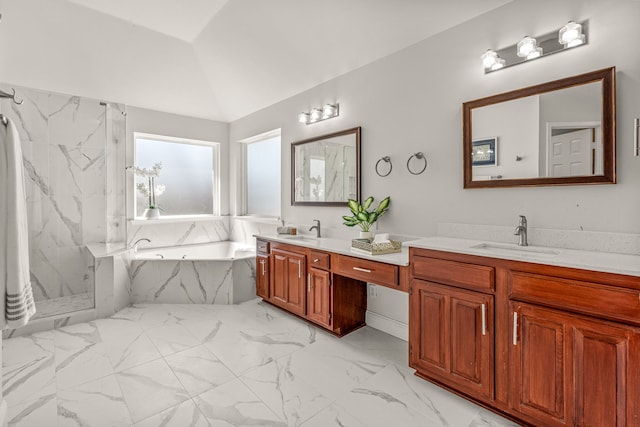 bathroom featuring lofted ceiling, marble finish floor, a sink, and a garden tub