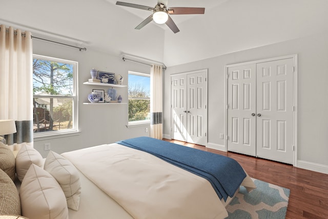 bedroom with multiple closets, vaulted ceiling, ceiling fan, wood finished floors, and baseboards