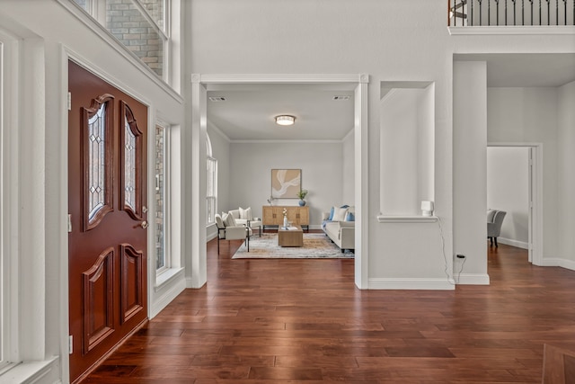 entryway with a high ceiling, dark wood-style flooring, and baseboards