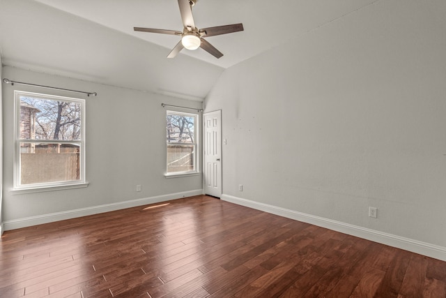 empty room with dark wood-style floors, lofted ceiling, a ceiling fan, and baseboards