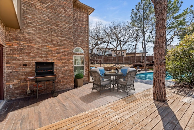 wooden terrace featuring a fenced in pool, outdoor dining area, and fence