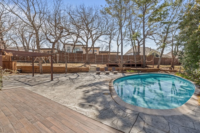 view of swimming pool featuring a patio area, a fenced backyard, and a deck