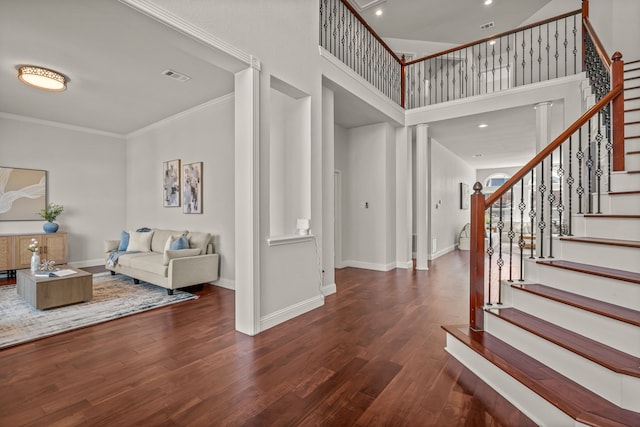 foyer with stairway, wood finished floors, visible vents, and baseboards