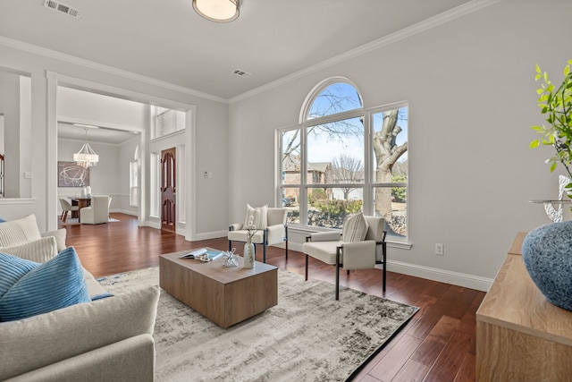 living room with a notable chandelier, wood finished floors, visible vents, baseboards, and crown molding