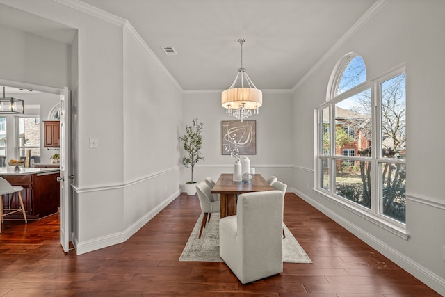 dining area with a chandelier, dark wood-type flooring, a wealth of natural light, and visible vents