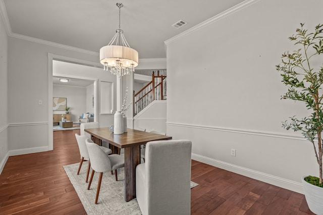 dining area featuring crown molding, visible vents, a chandelier, and hardwood / wood-style floors