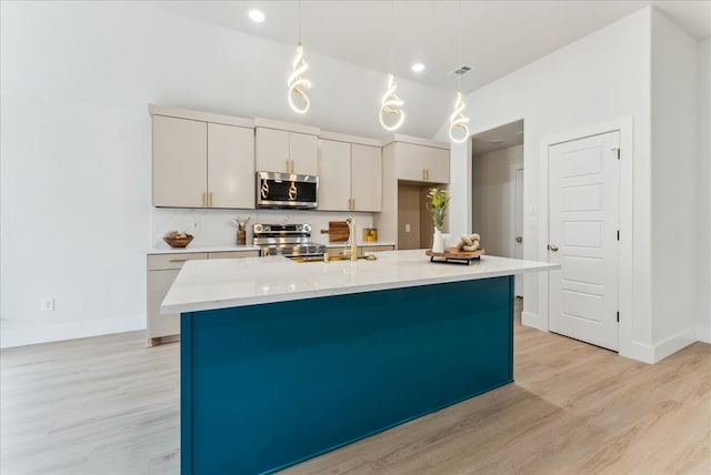 kitchen with stainless steel appliances, light countertops, visible vents, and light wood finished floors