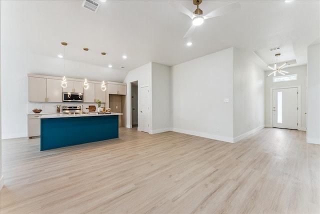 kitchen with visible vents, a ceiling fan, appliances with stainless steel finishes, open floor plan, and light wood-type flooring