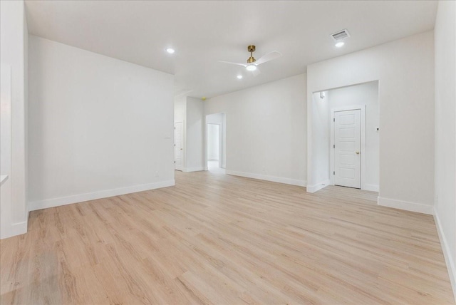 unfurnished room with baseboards, light wood-style flooring, visible vents, and a ceiling fan