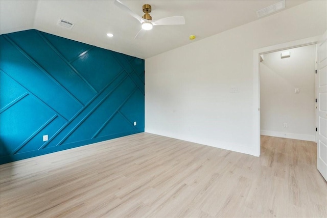 unfurnished room featuring light wood-type flooring, visible vents, a ceiling fan, and lofted ceiling