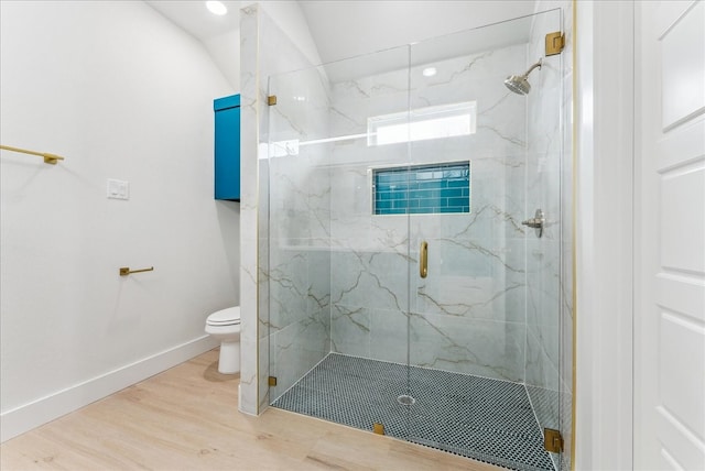 full bathroom with toilet, a marble finish shower, baseboards, and wood finished floors