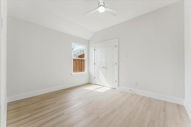 empty room featuring vaulted ceiling, ceiling fan, baseboards, and wood finished floors