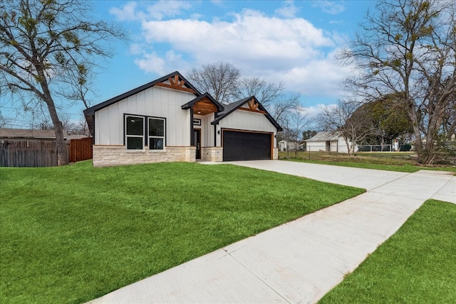 view of front of house featuring a front yard, fence, a garage, stone siding, and driveway