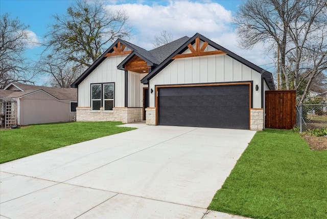 modern inspired farmhouse featuring a garage, stone siding, driveway, board and batten siding, and a front yard