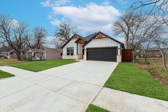 view of front facade with fence, driveway, stone siding, a front lawn, and board and batten siding