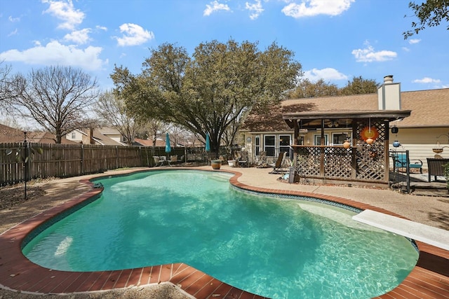 view of pool with a patio, a diving board, a fenced backyard, and a fenced in pool