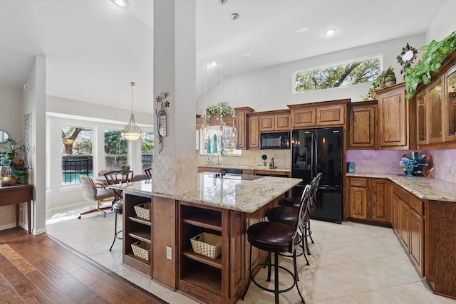 kitchen with a kitchen bar, black appliances, brown cabinets, and open shelves