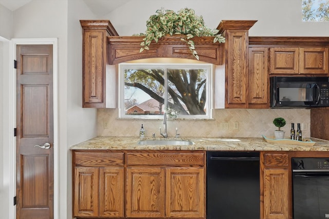 kitchen with a sink, brown cabinets, tasteful backsplash, and black microwave