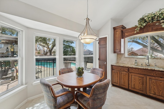 dining area with baseboards, light tile patterned flooring, and vaulted ceiling