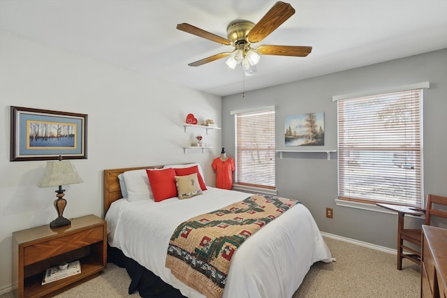 carpeted bedroom with ceiling fan and baseboards