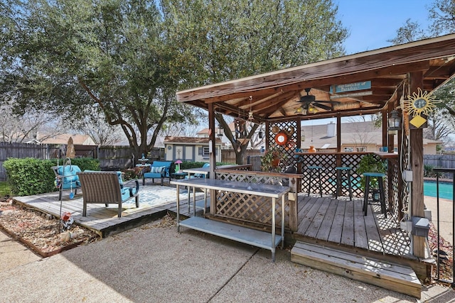 wooden deck with an outdoor living space, an outdoor structure, a fenced backyard, and a fenced in pool