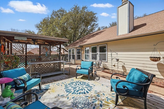 wooden deck with an outdoor hangout area, fence, and a patio area