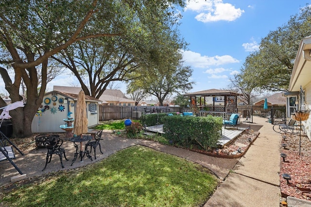 view of yard with a deck, an outdoor structure, and a fenced backyard