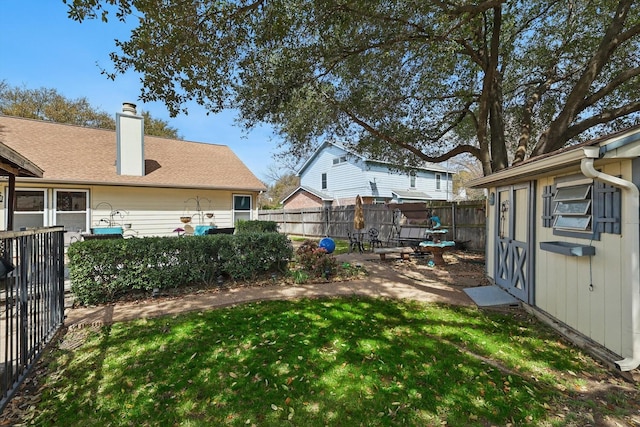 view of yard featuring a fenced backyard, a shed, a patio area, and an outdoor structure