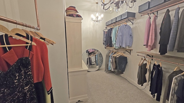 spacious closet featuring a chandelier and carpet