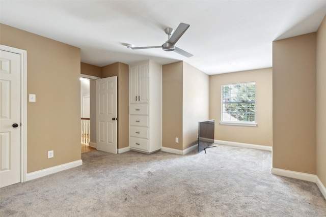 unfurnished bedroom featuring a ceiling fan, light colored carpet, and baseboards