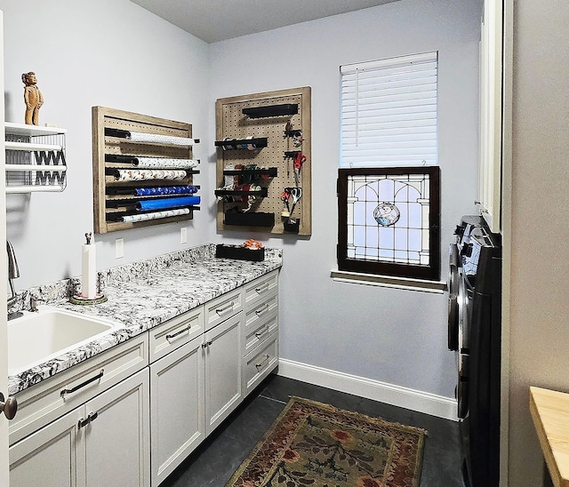 kitchen with a sink and baseboards