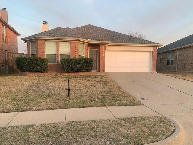 ranch-style house featuring a garage, a front yard, brick siding, and driveway