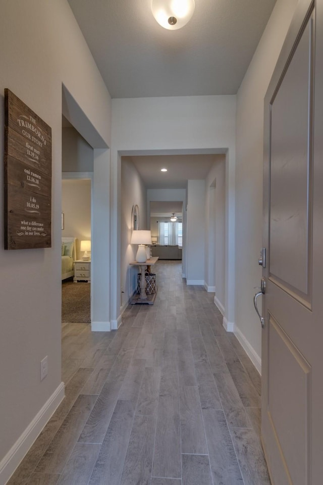 hallway featuring baseboards and wood finished floors