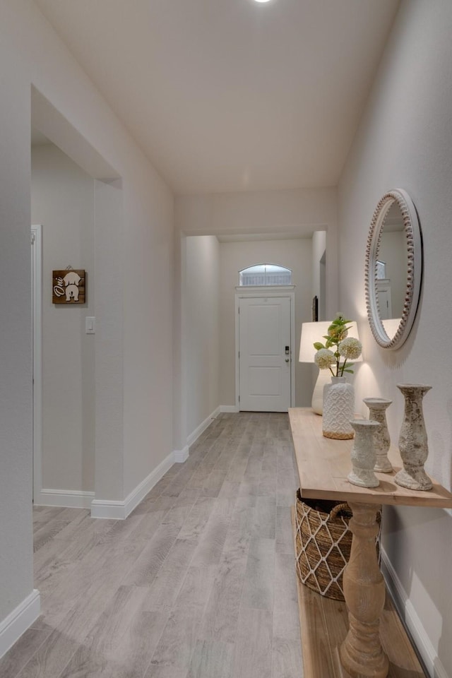 foyer entrance with light wood finished floors and baseboards