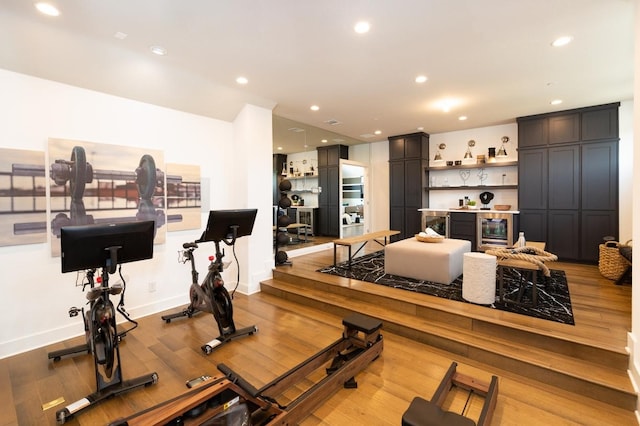 workout room featuring wine cooler, light wood-style flooring, baseboards, and recessed lighting