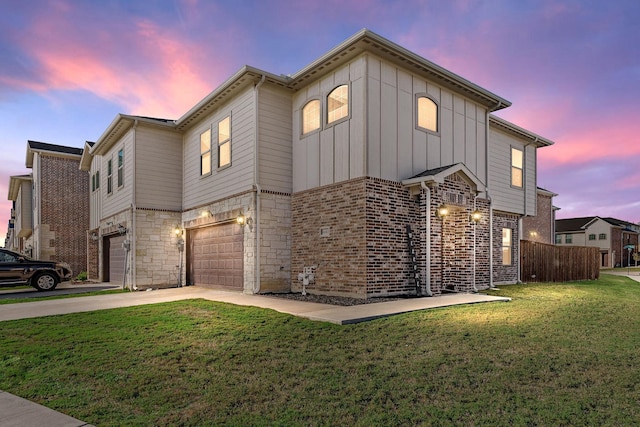 view of front of home with brick siding, a lawn, an attached garage, board and batten siding, and driveway