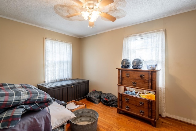 bedroom featuring multiple windows, a textured ceiling, and wood finished floors