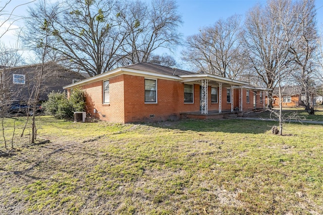 view of home's exterior with a porch, central air condition unit, brick siding, crawl space, and a lawn