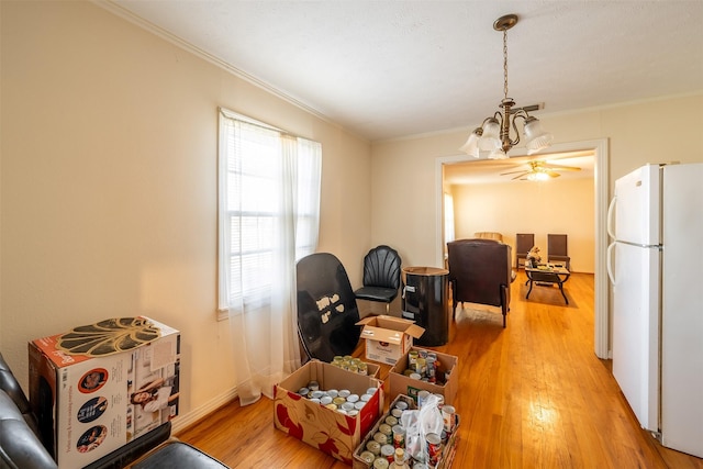 interior space featuring crown molding, baseboards, an inviting chandelier, and light wood-style floors