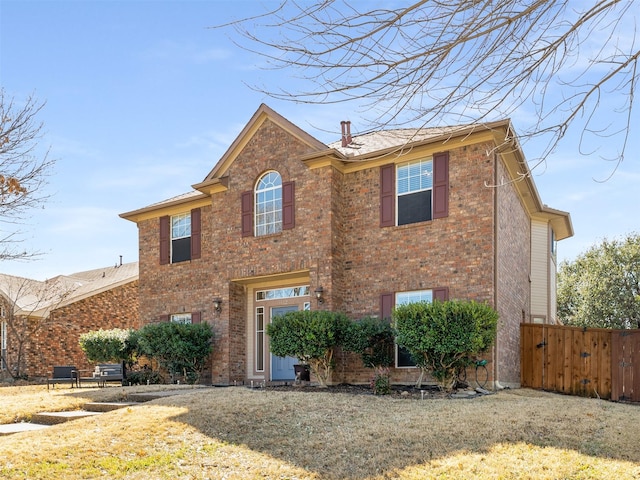 view of front facade with brick siding and fence