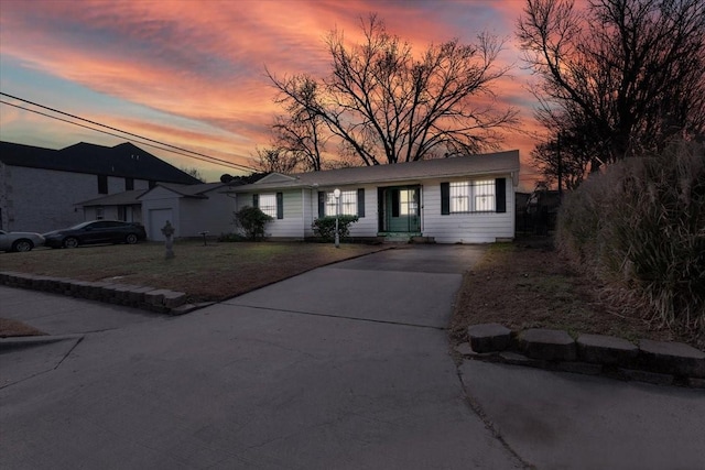 view of front of house with driveway, a yard, and an outdoor structure