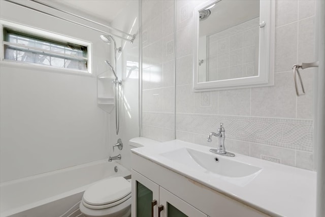 full bath with tasteful backsplash, toilet, vanity, shower / washtub combination, and tile walls