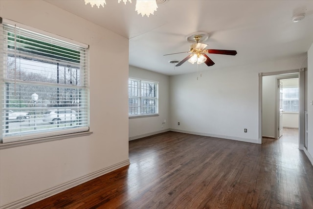 empty room featuring a ceiling fan, baseboards, and wood finished floors