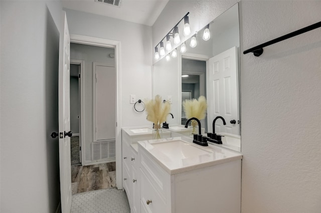 bathroom featuring visible vents, vanity, and tile patterned floors