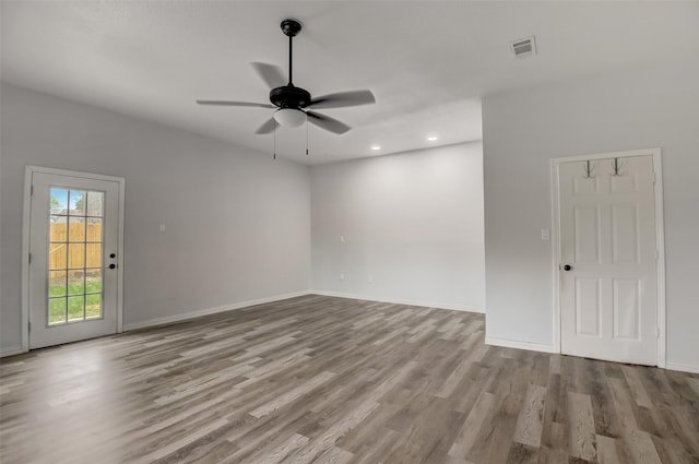 empty room with ceiling fan, recessed lighting, wood finished floors, visible vents, and baseboards