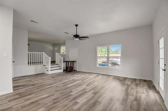 interior space featuring ceiling fan, wood finished floors, visible vents, baseboards, and stairs