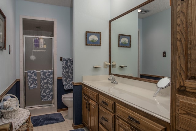 full bath featuring a stall shower, a textured ceiling, toilet, and vanity