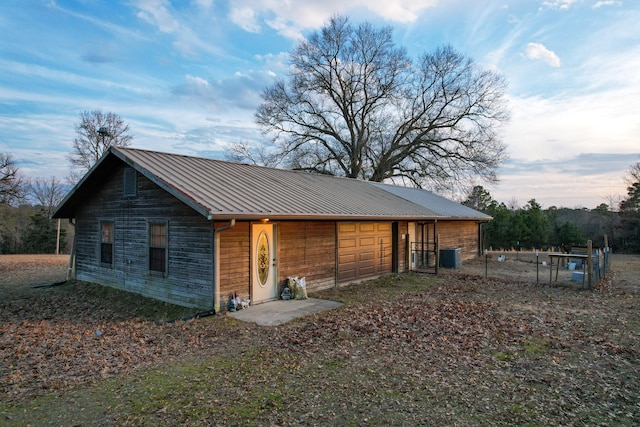 rear view of property with metal roof and central AC