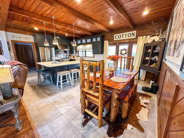 dining area featuring wooden ceiling and beam ceiling